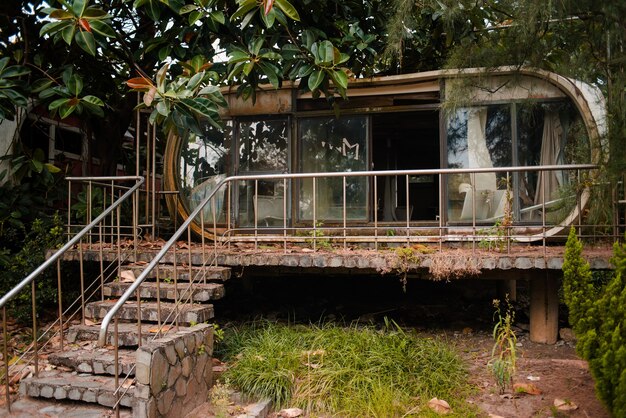 Antiguo edificio abandonado con ventanas de vidrio en un jardín en Wanli UFO Village, Taiwán