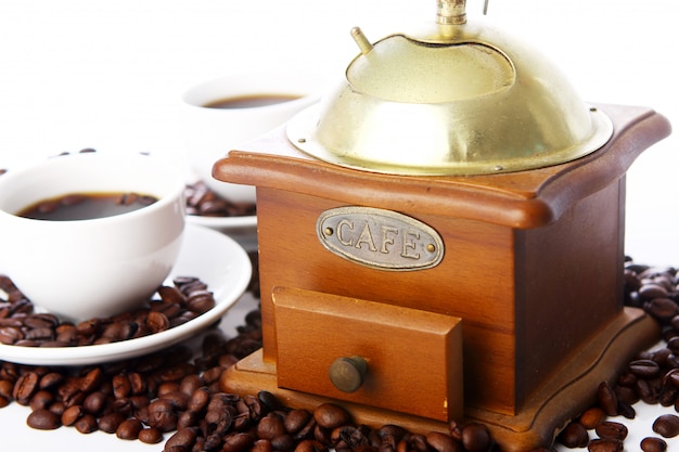 Antiguo molinillo de café con taza blanca