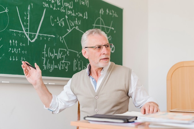 Foto gratuita antiguo profesor explicando en aula