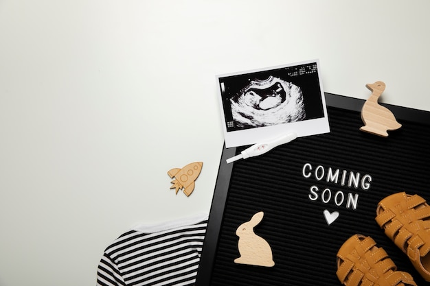 Foto gratuita anuncio de embarazo de vista superior con artículos para bebés