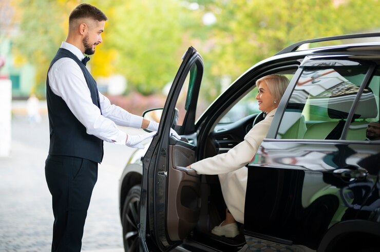 Foto gratuito aparcacoches ayudando a mujer a aparcar su coche