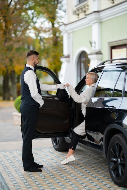 Foto gratuita aparcacoches ayudando a mujer a aparcar su coche