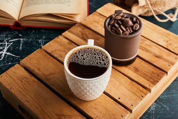 Aparte una taza de café con espuma y granos.