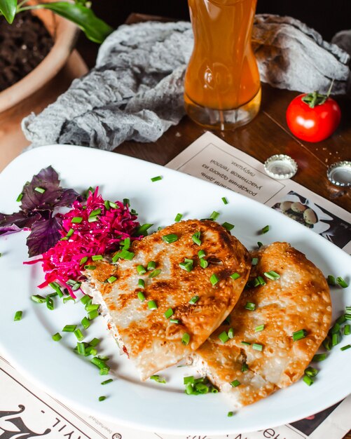 Aperitivo servido con repollo, cebollín picado y albahaca