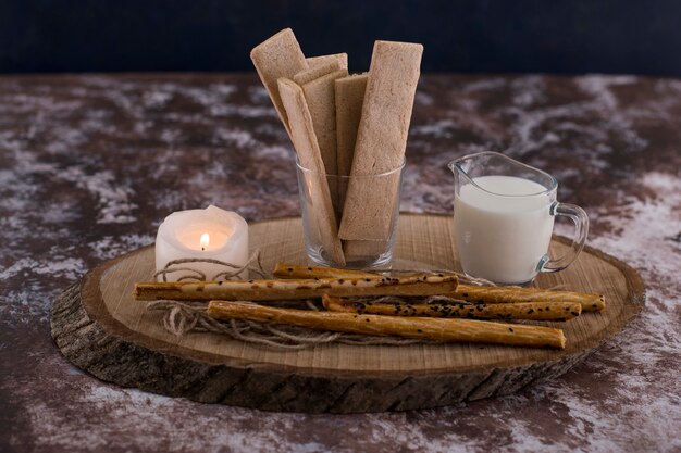 Aperitivos y galletas con un vaso de leche en rústico