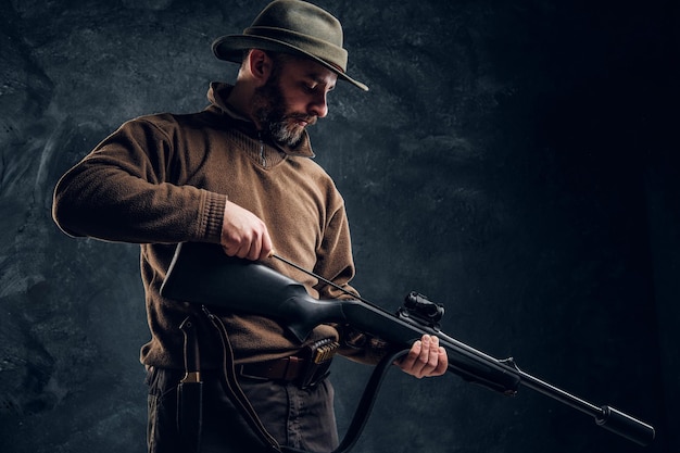 Foto gratuita apertura de la temporada de caza de primavera. un hombre limpia el cañón del rifle, mantenimiento antes de cazar.