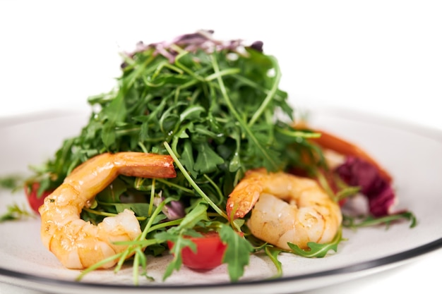 Apetitosa ensalada con rúcula, tomates y sabrosos camarones