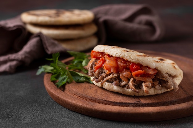 Apetitosas arepas con carne y tomates