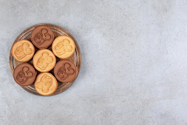 Apetitoso paquete de galletas sobre tabla de madera sobre fondo de mármol. Foto de alta calidad