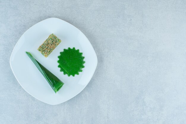 Apetitoso snack de ciruela guinda y lokum en el plato, sobre el fondo de mármol. Foto de alta calidad