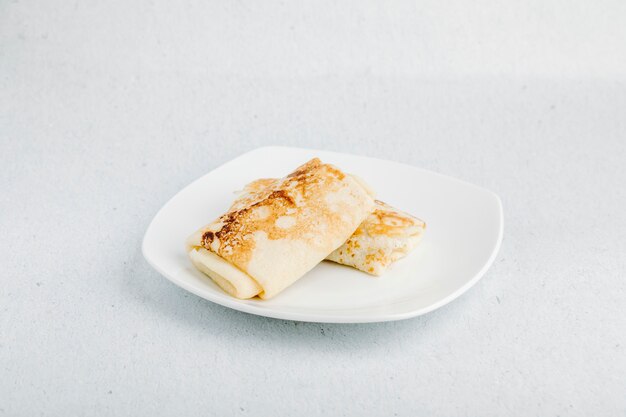 Apetizer ruso blinchik, crepes dentro de un plato blanco.