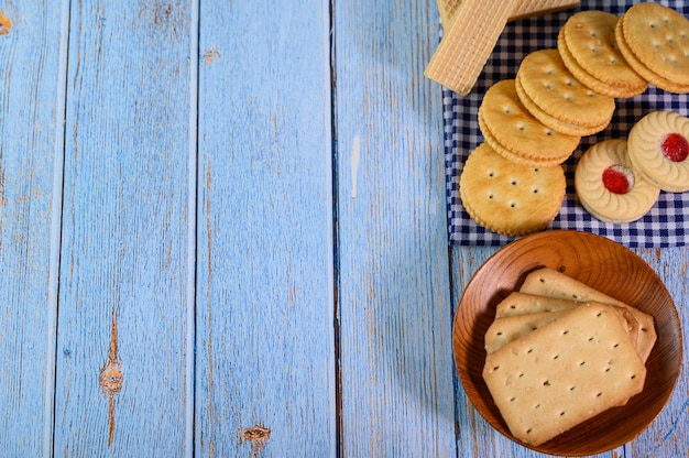 Apila muchos tipos de galletas en un plato y ponlas sobre una mesa de madera.