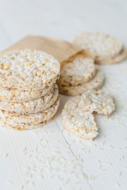 Apilados de arroz inflado con granos en mesa de madera blanca