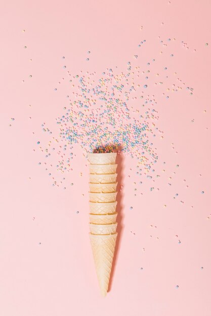 Apilados de galletas con bolas de espolvorear sobre fondo rosa