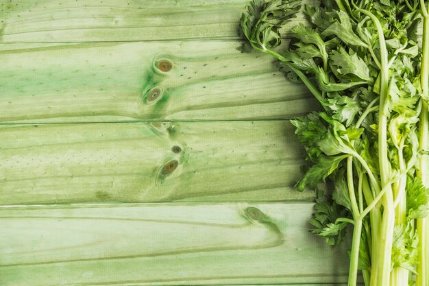 Apio fresco en tablón de madera verde