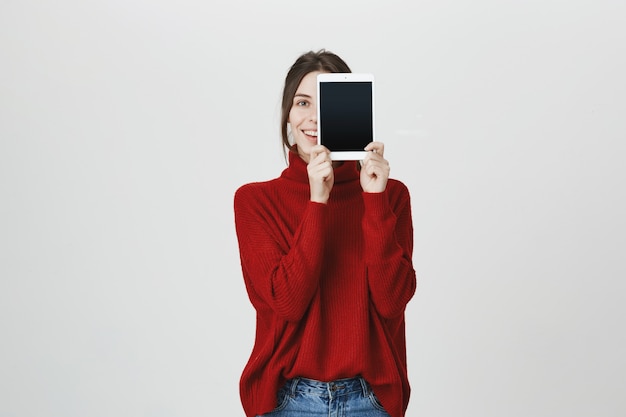 La aplicación de publicidad de niña sonriente, muestra la pantalla de la tableta digital