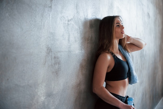 Apoyado en la pared. Foto de hermosa mujer rubia en el gimnasio en su fin de semana