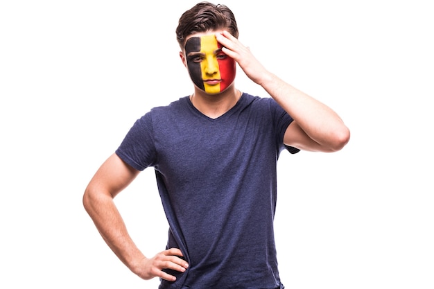 El apoyo del ventilador perdedor molesto del equipo nacional de Bélgica con la cara pintada aislado sobre fondo blanco.