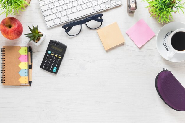 Apple con calculadora y suministros de oficina en escritorio de madera