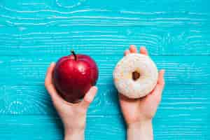 Foto gratuita apple y donut en la mesa de madera azul