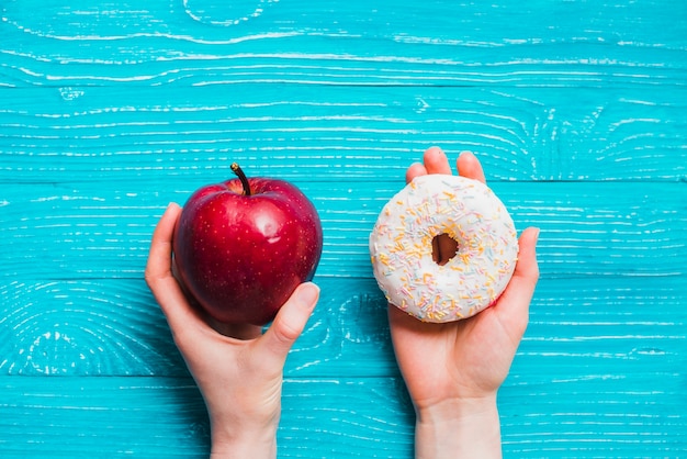 Apple y donut en la mesa de madera azul