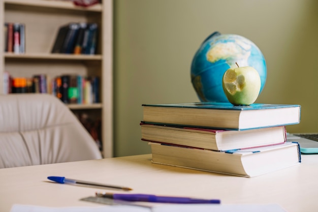 Foto gratuita apple y libros sobre el escritorio