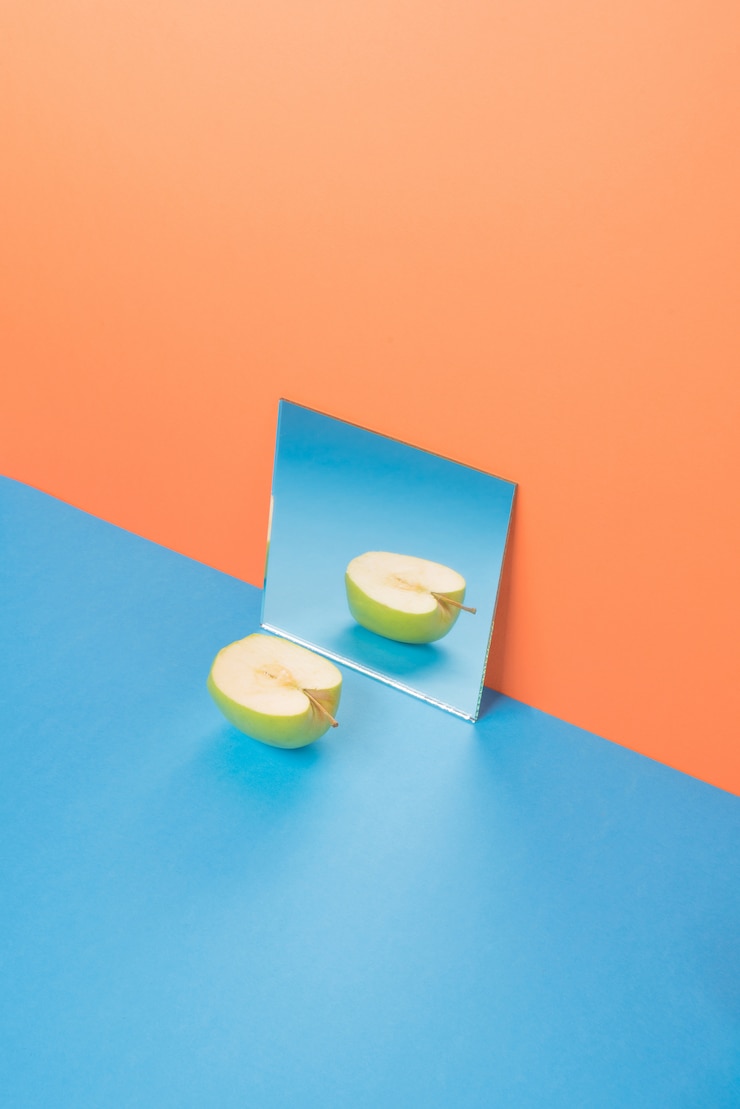 Foto gratuito apple en mesa azul aislado en naranja