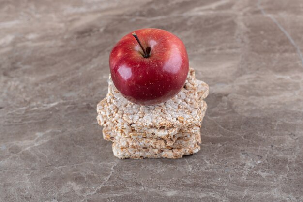 Apple y un montón de tortas de arroz inflado en la superficie de mármol