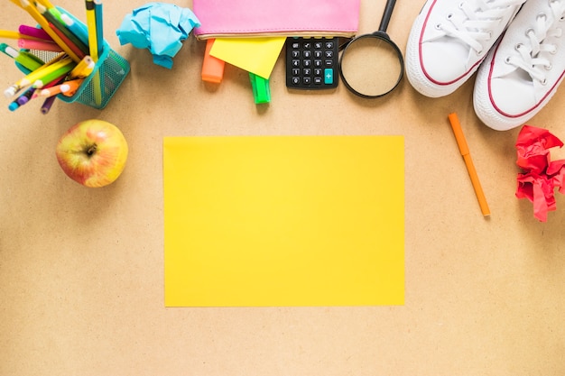 Foto gratuita apple y zapatillas de deporte cerca de papelería y papel