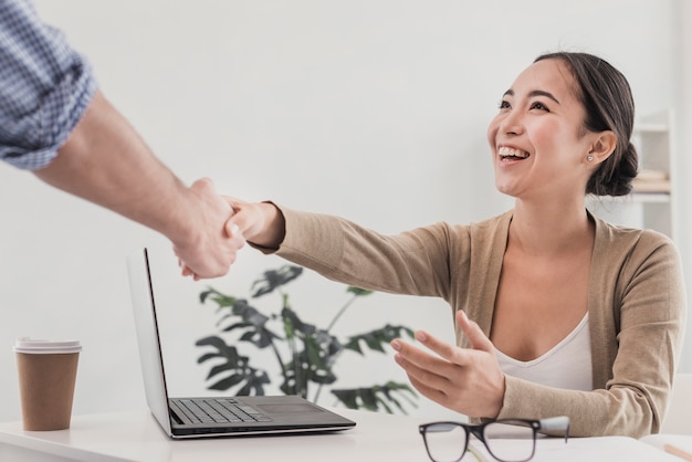 Foto gratuita apretón de manos en la oficina con hermosa mujer