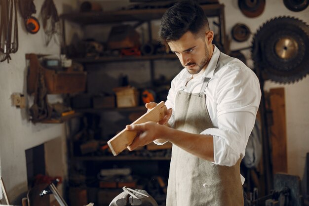 Apuesto carpintero trabajando con madera