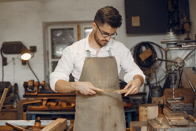 Apuesto carpintero trabajando con madera