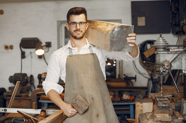 Apuesto carpintero trabajando con madera