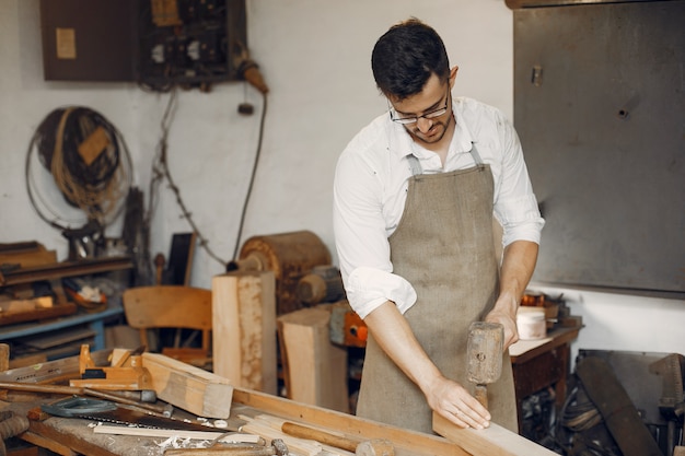 Apuesto carpintero trabajando con madera