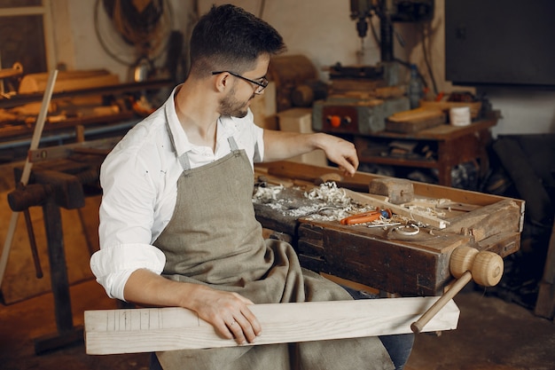 Apuesto carpintero trabajando con madera