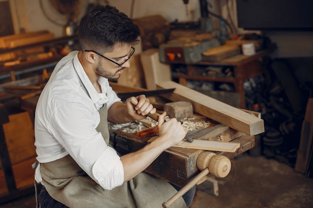 Foto gratuita apuesto carpintero trabajando con madera