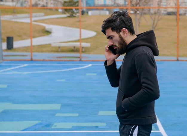 Apuesto deportista se para en el campo de fútbol y piensa Foto de alta calidad