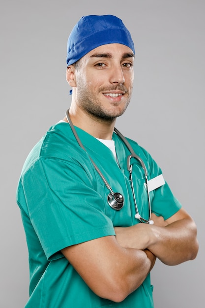 Foto gratuita apuesto doctor masculino posando con los brazos cruzados