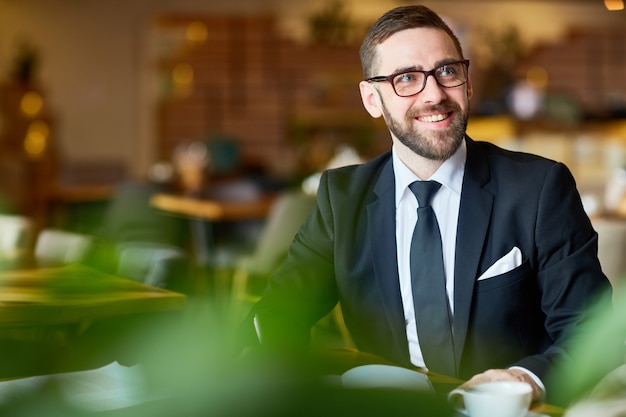 Apuesto empresario que trabaja desde el café