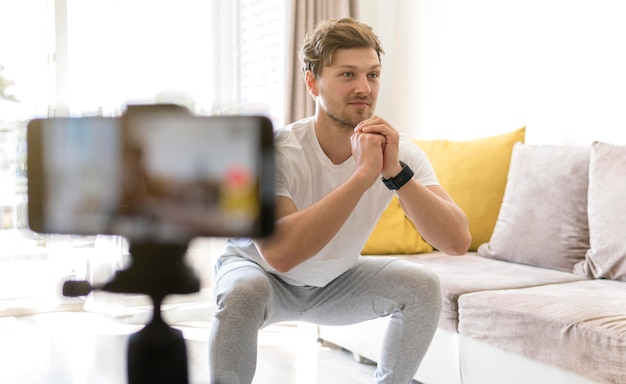 Apuesto entrenamiento de grabación masculina en casa