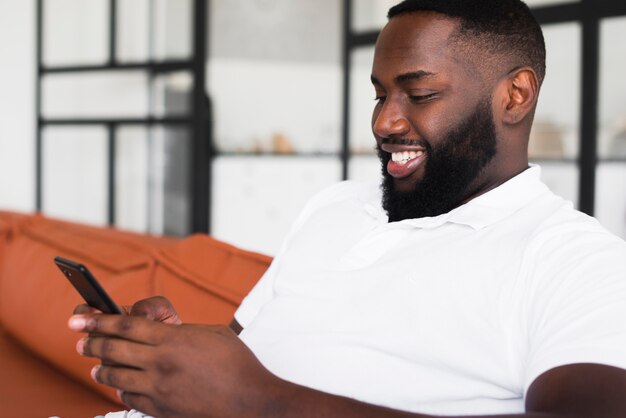 Apuesto hombre adulto navegando por su teléfono