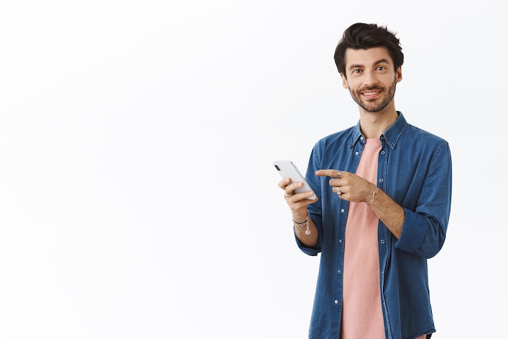 Foto gratuito un apuesto hombre barbudo hablando contigo y señalando la pantalla del teléfono inteligente sonriendo y diciendo su propia opinión sobre una buena aplicación como nuevas fotos que un amigo publicó en línea en las redes sociales con fondo blanco