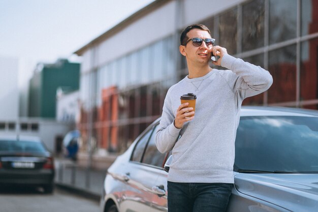 Apuesto hombre exitoso en el coche con celular