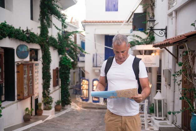 Apuesto hombre mirando el mapa de la ciudad en un viaje