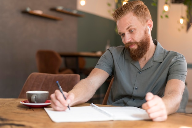 Foto gratuita apuesto hombre moderno tomando notas