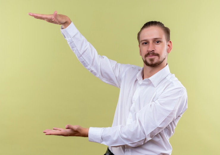 Foto gratuito apuesto hombre de negocios con camisa blanca que muestra un cartel de gran tamaño que parece seguro, símbolo de medida de pie sobre fondo verde oliva