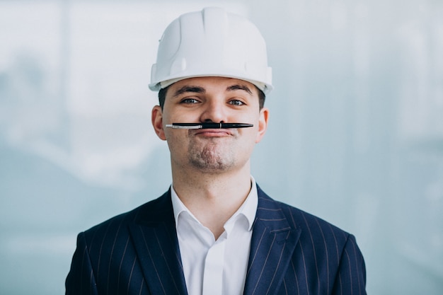 Apuesto hombre de negocios ingeniero en casco en un edificio