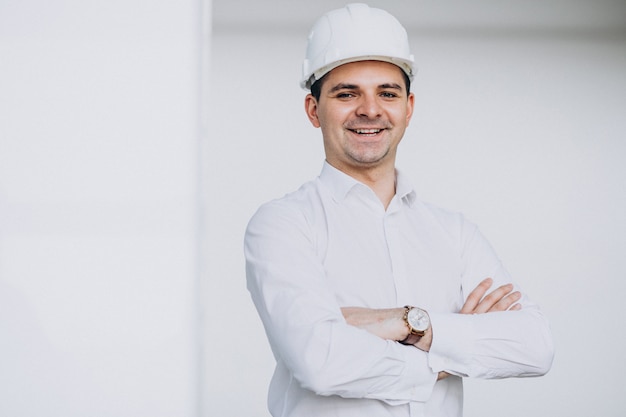 Apuesto hombre de negocios ingeniero en casco en un edificio