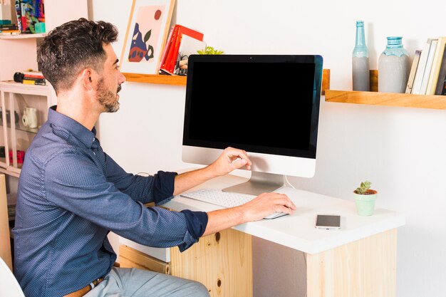 Apuesto hombre de negocios trabajando en la computadora en su lugar de trabajo