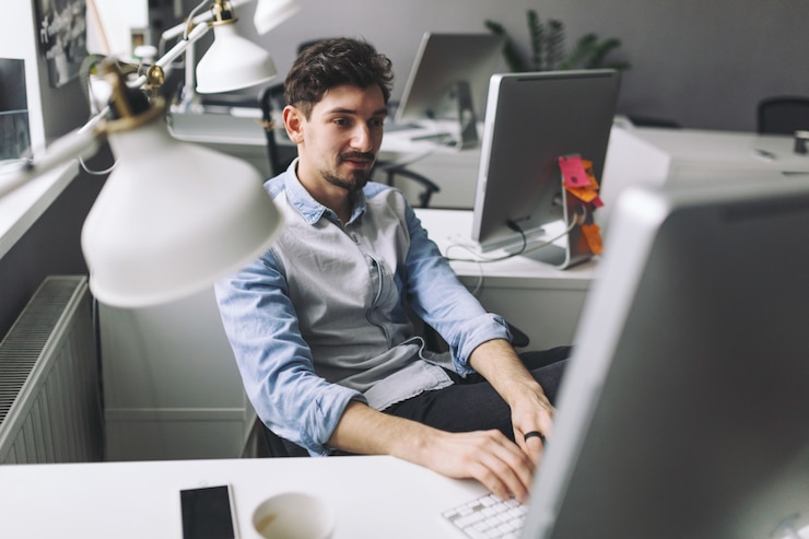 Foto gratuito un apuesto hombre de negocios trabajando en una oficina.